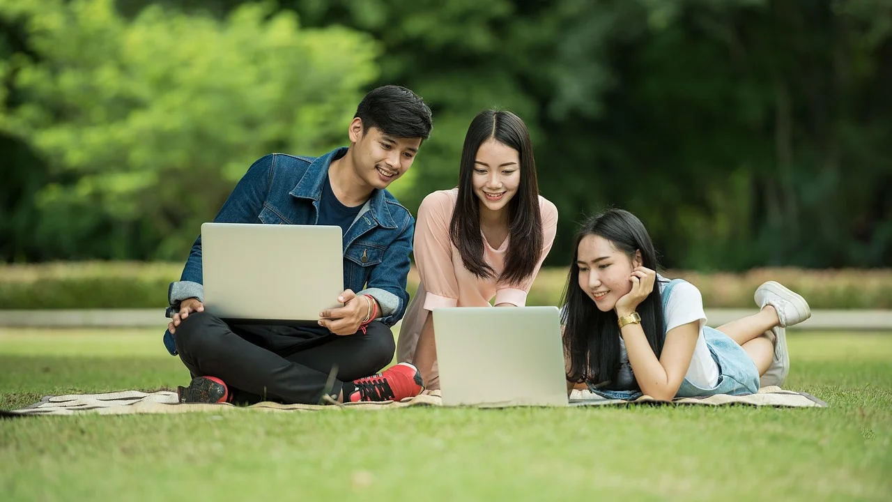 Jovem compara informações de cursos em um computador.