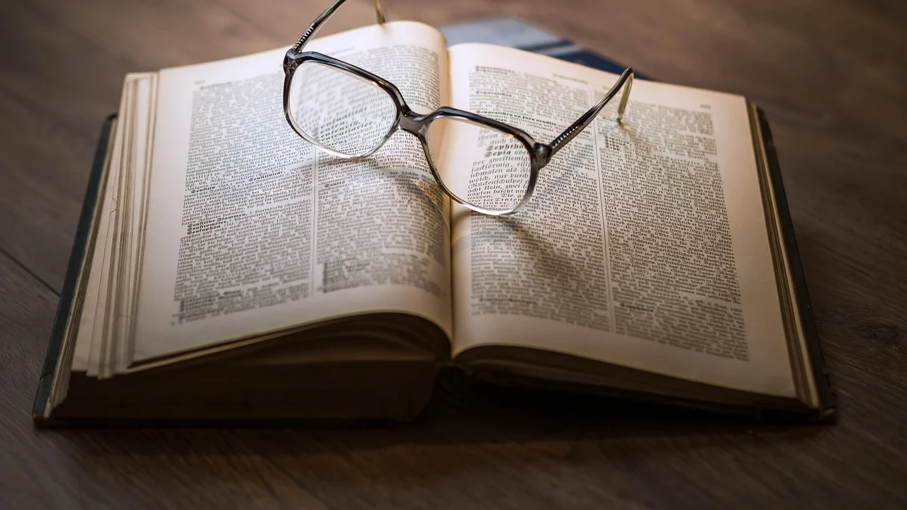 Mesa de estudos com livros, canetas e folhas de anotação.