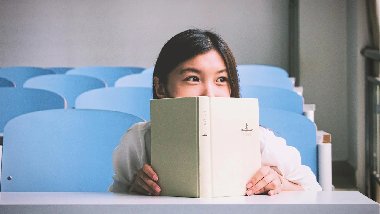 Educadora orienta estudante em atividade escrita individual.
