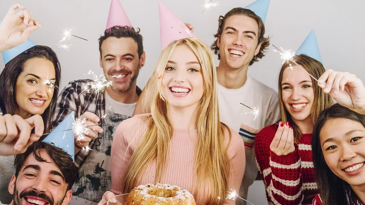 Amigas celebram um aniversário com bolo e velas.