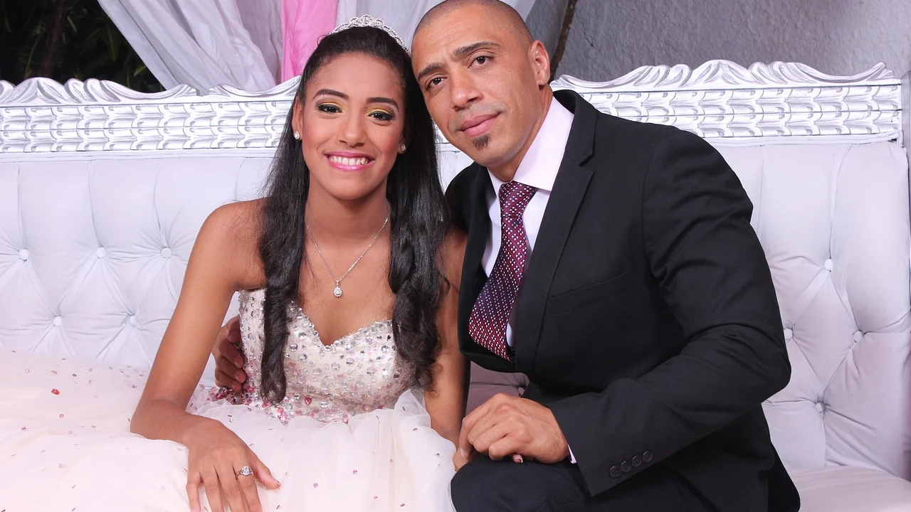 Família reunida em volta de bolo de aniversário para o pai
