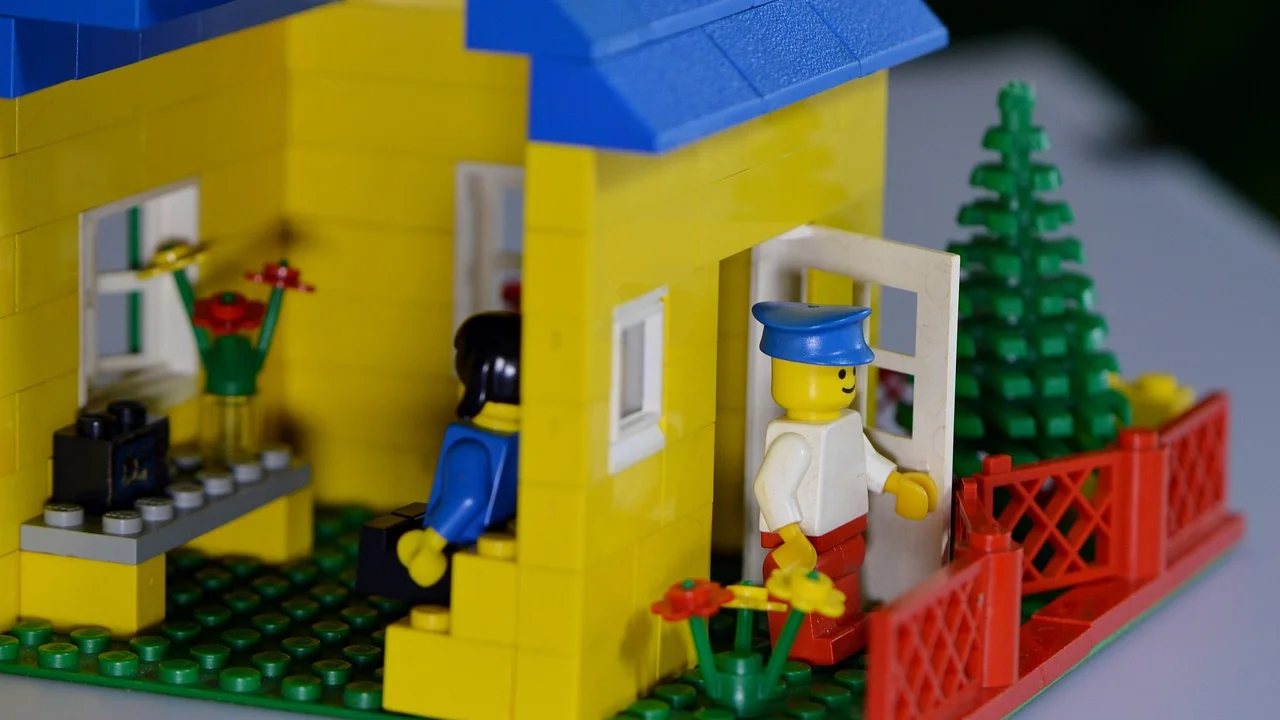 Educadora acompanha brincadeira com materiais coloridos.