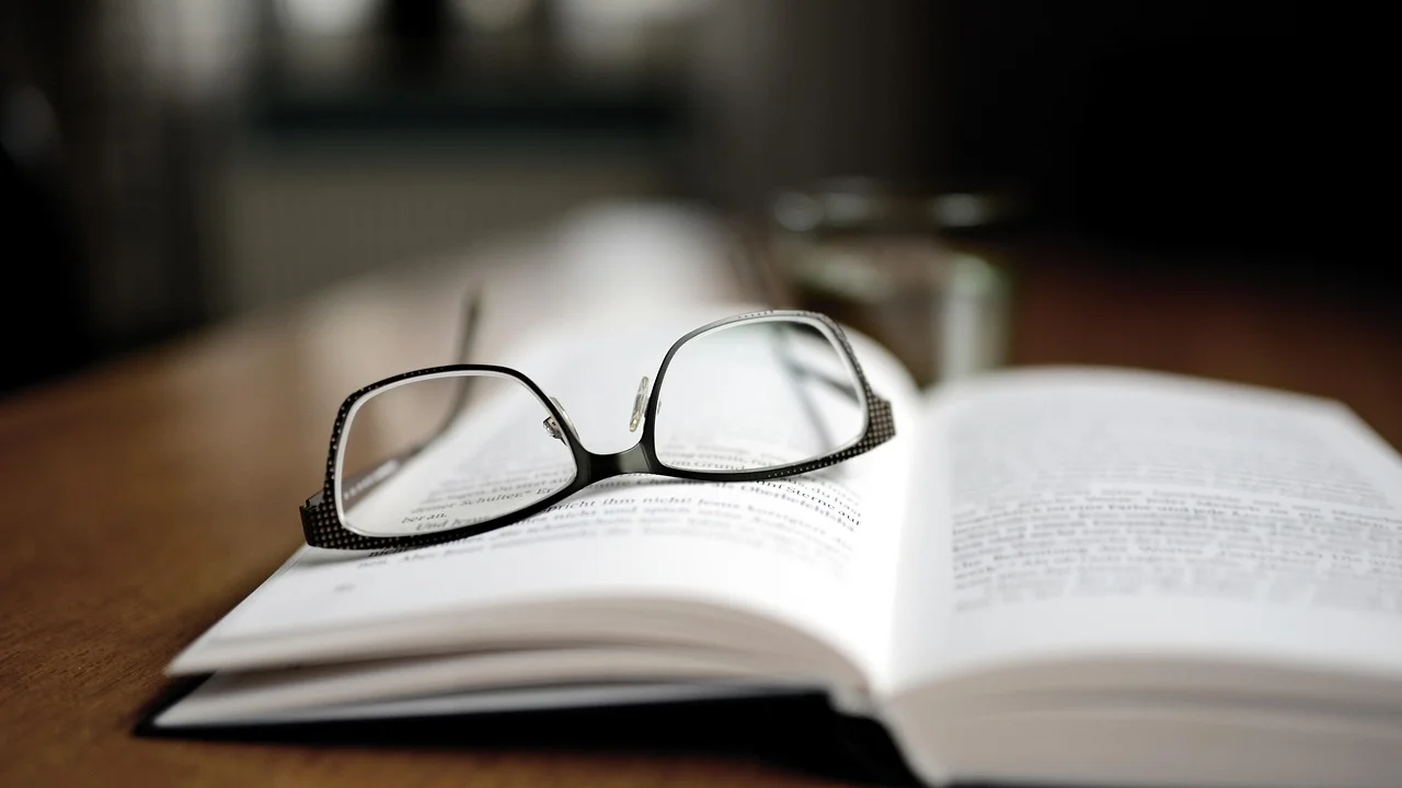 Caderno, canetas e livros usados em atividades de leitura e escrita.