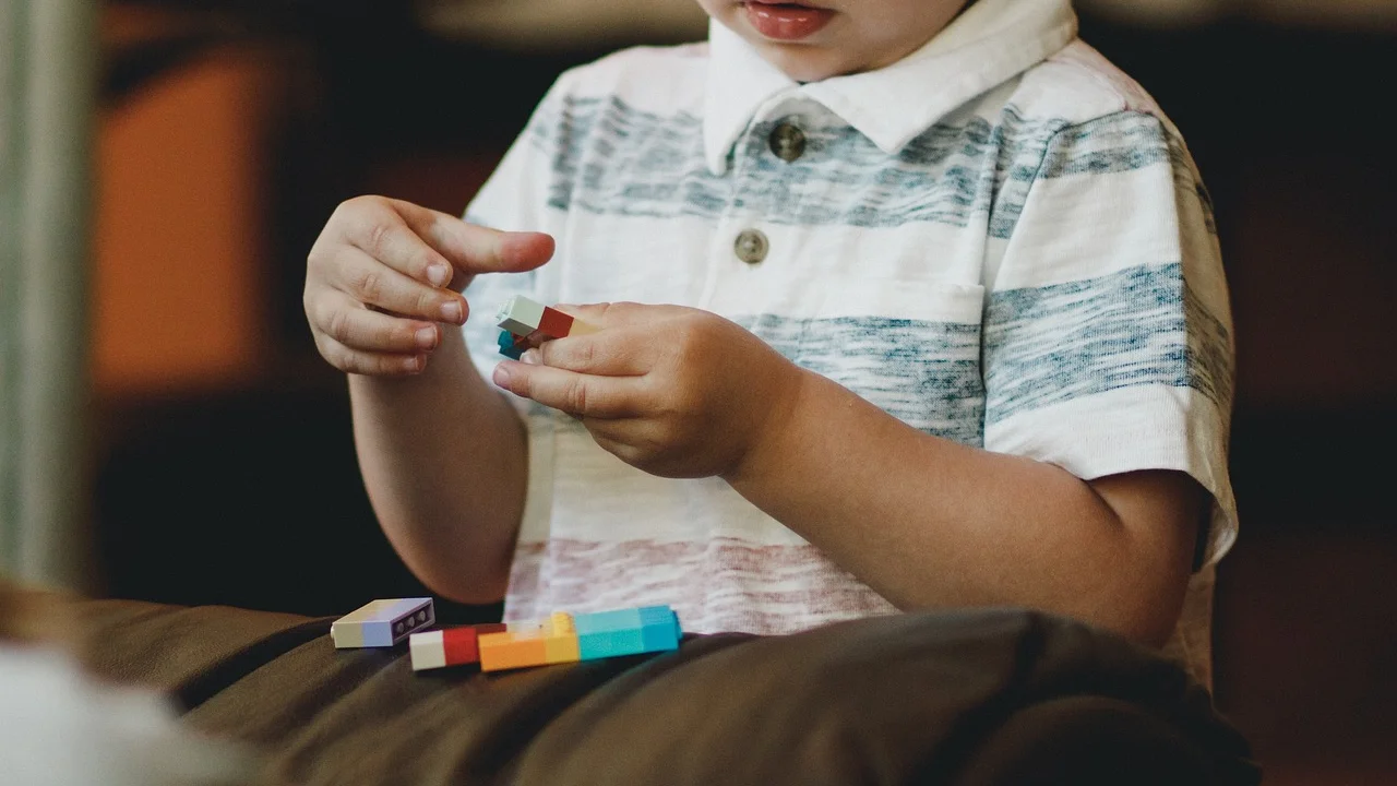 Mãos infantis fazendo rabiscos coloridos em papel