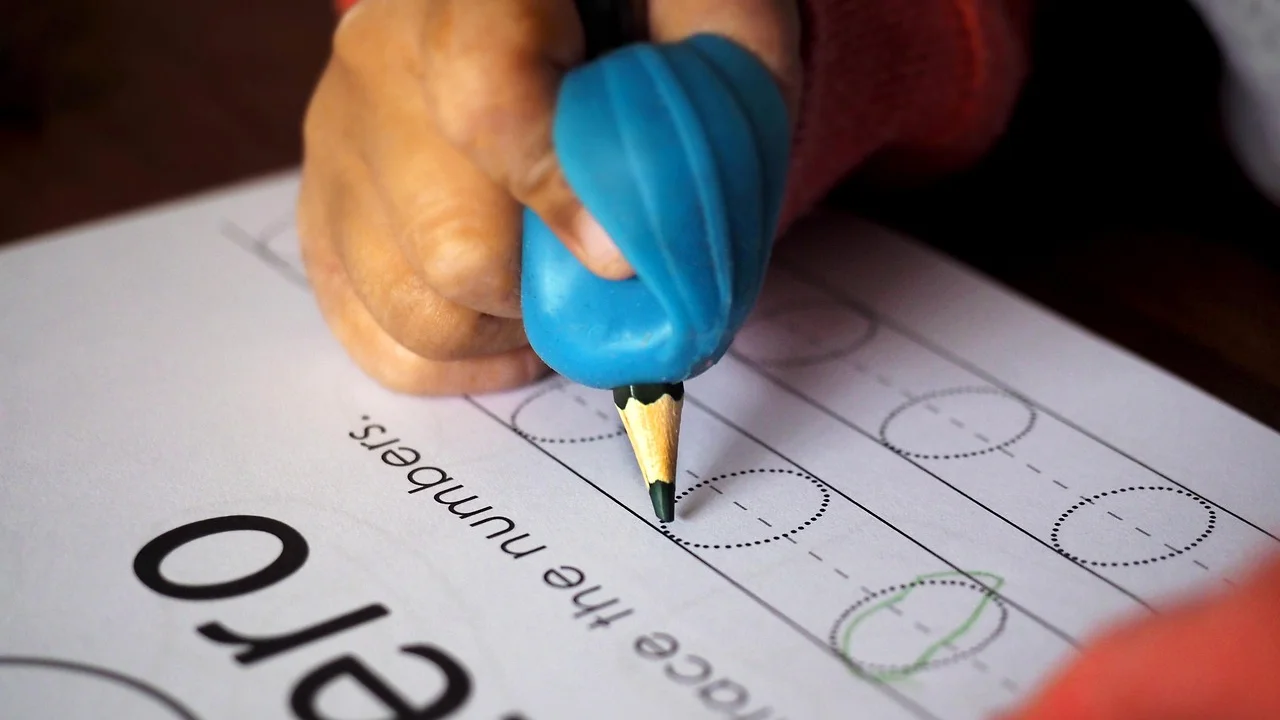 Mão segurando lápis para registrar palavras no papel