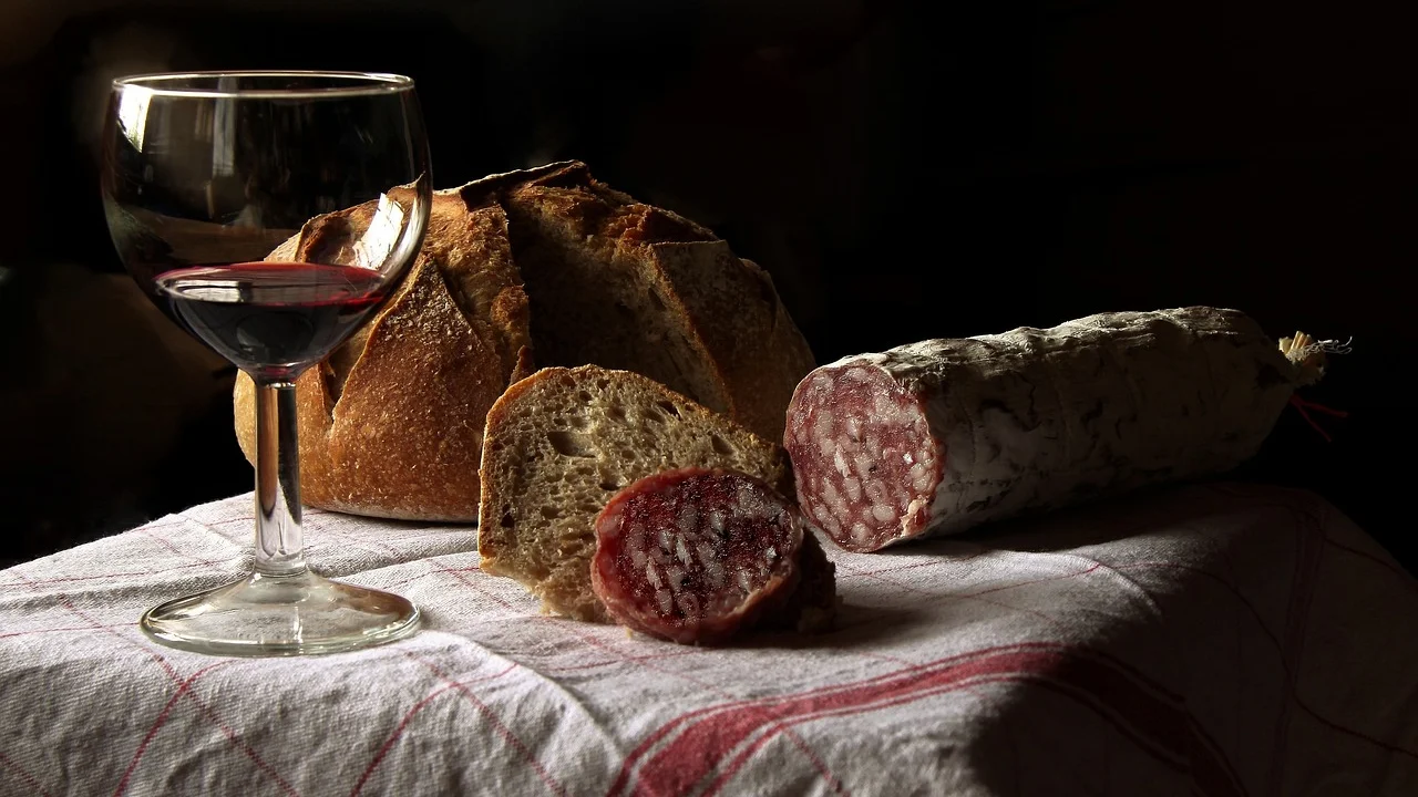 Bíblia aberta ao lado de alimentos em uma mesa de madeira.