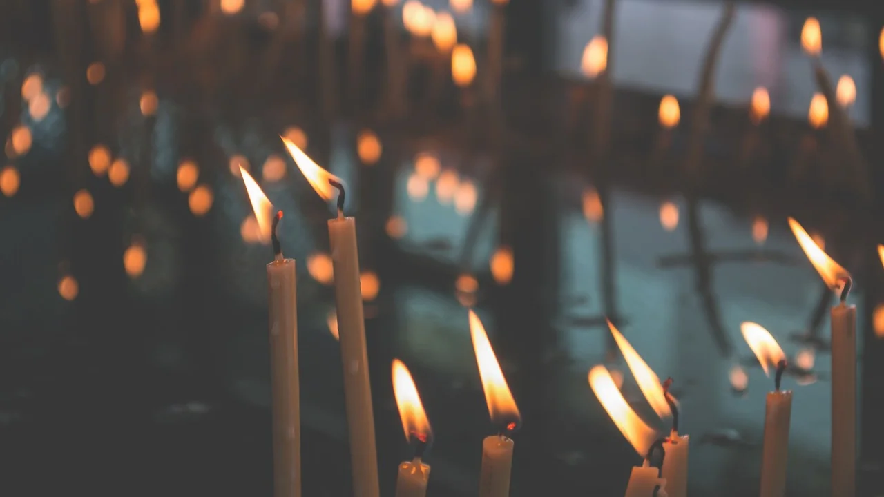 Vela acesa em ambiente escuro, símbolo de luz e reflexão
