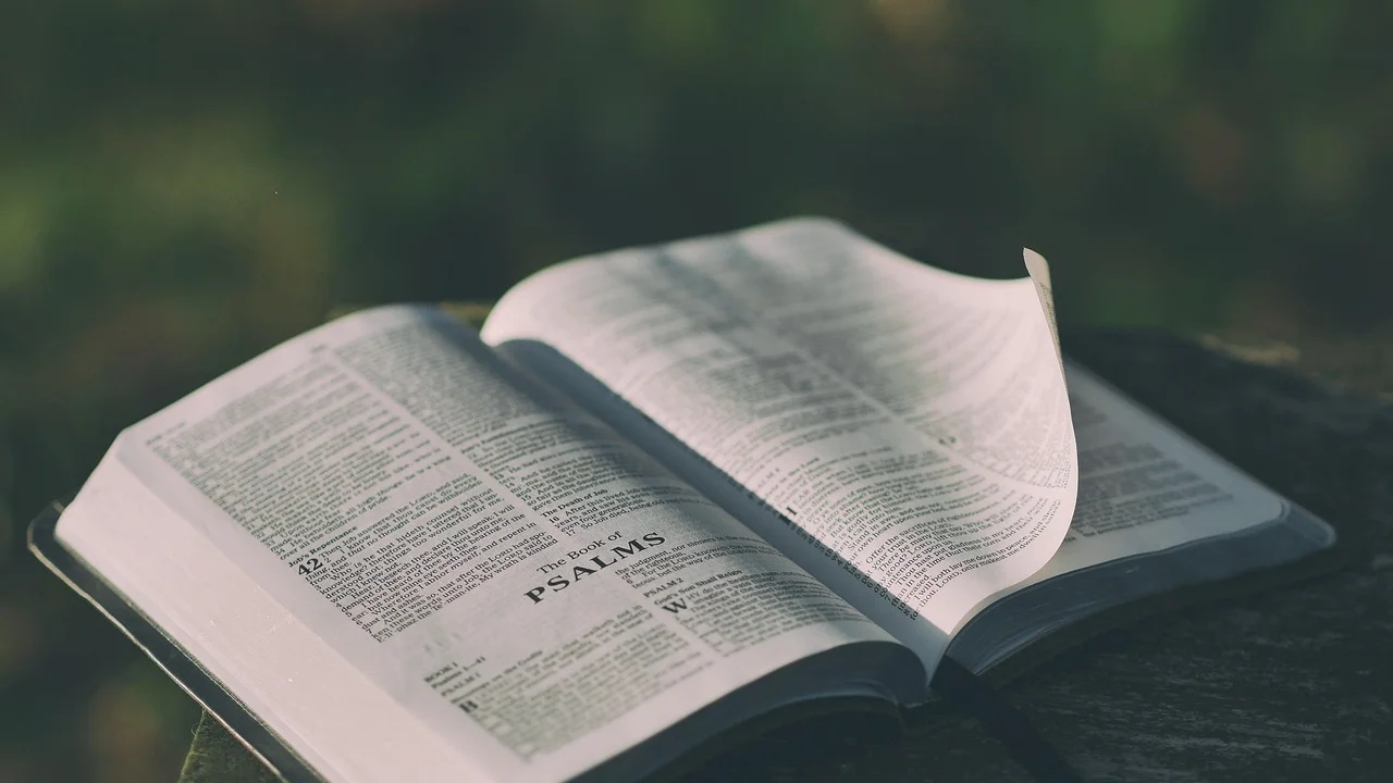 Velas acesas ao lado de um livro religioso