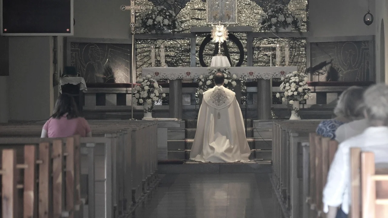 Interior silencioso de uma igreja com bancos e altar ao fundo.