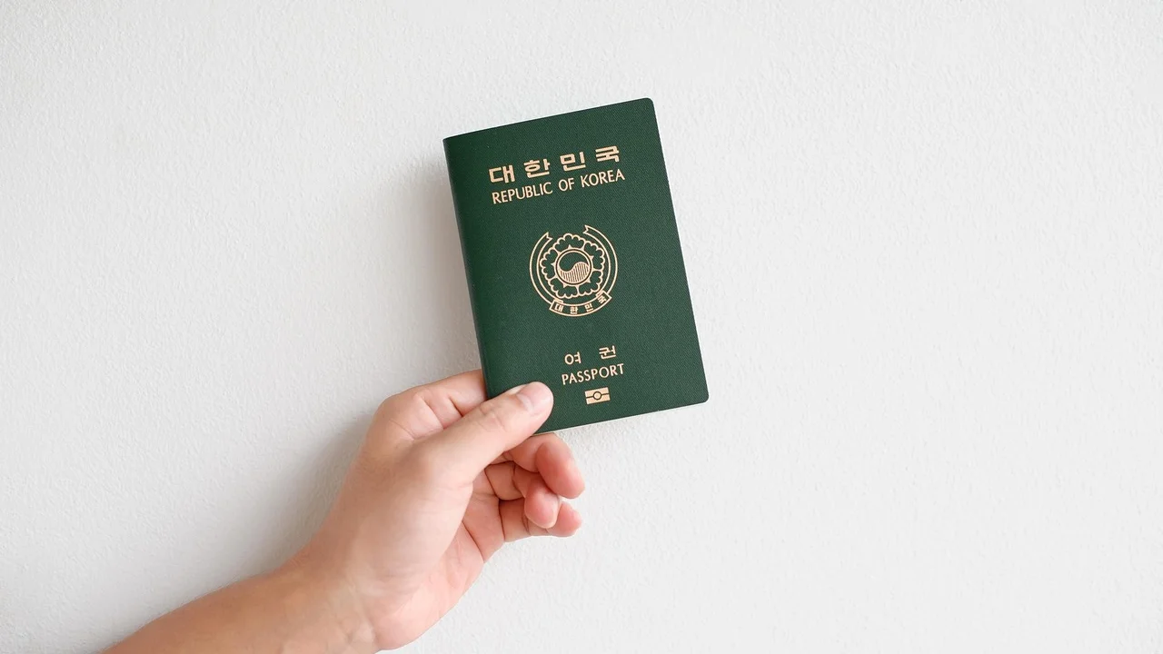 Passaporte brasileiro aberto ao lado de documentos de viagem.