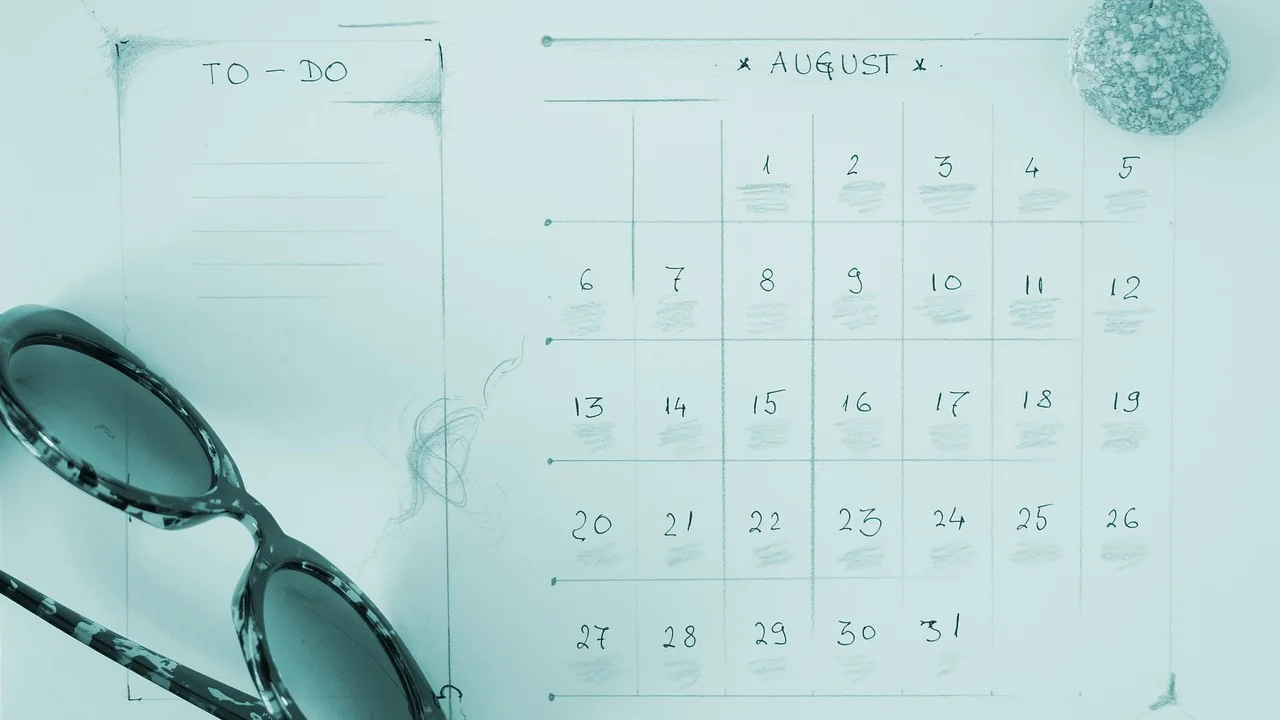 Funcionário conferindo datas de férias em agenda de mesa.