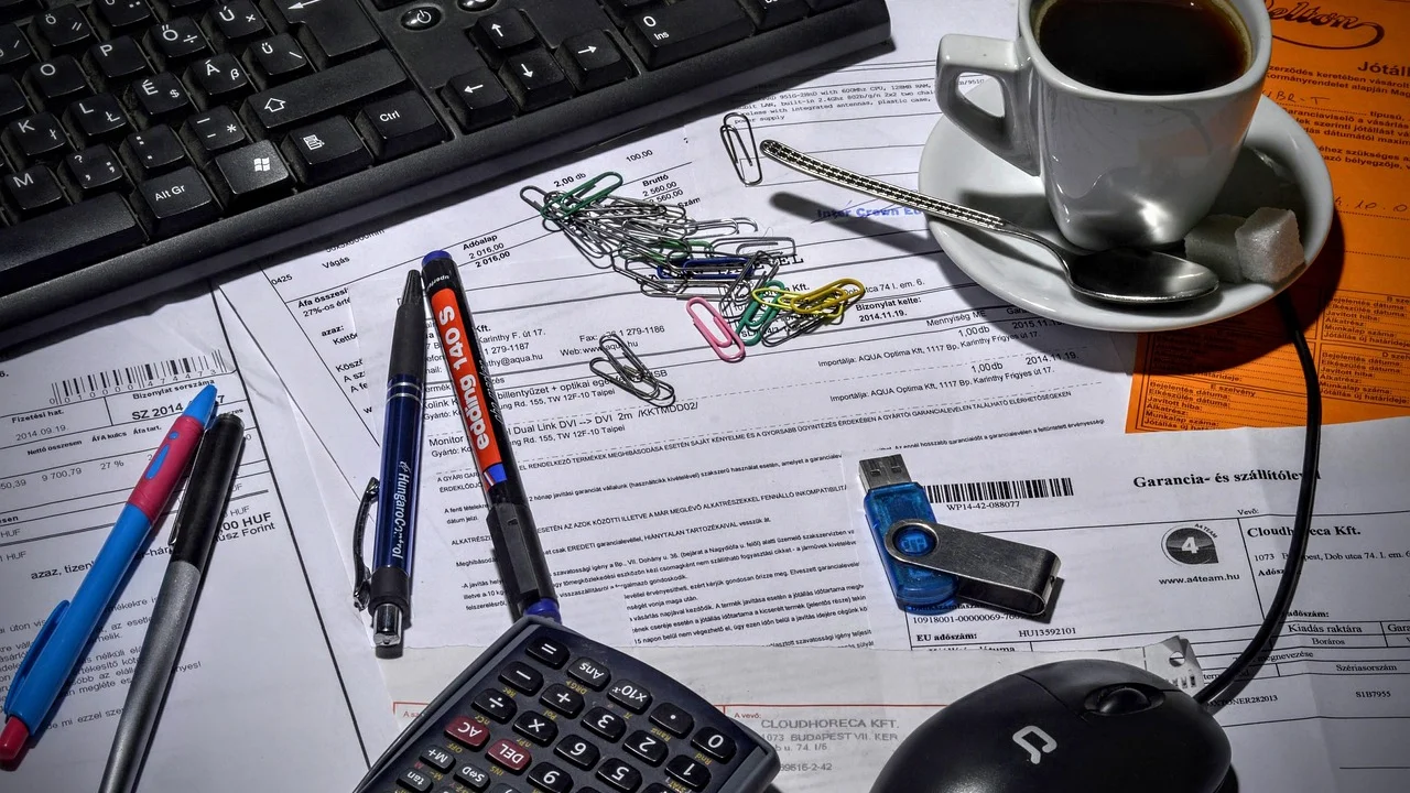Profissional organiza comprovantes e registros de vendas em mesa de trabalho.