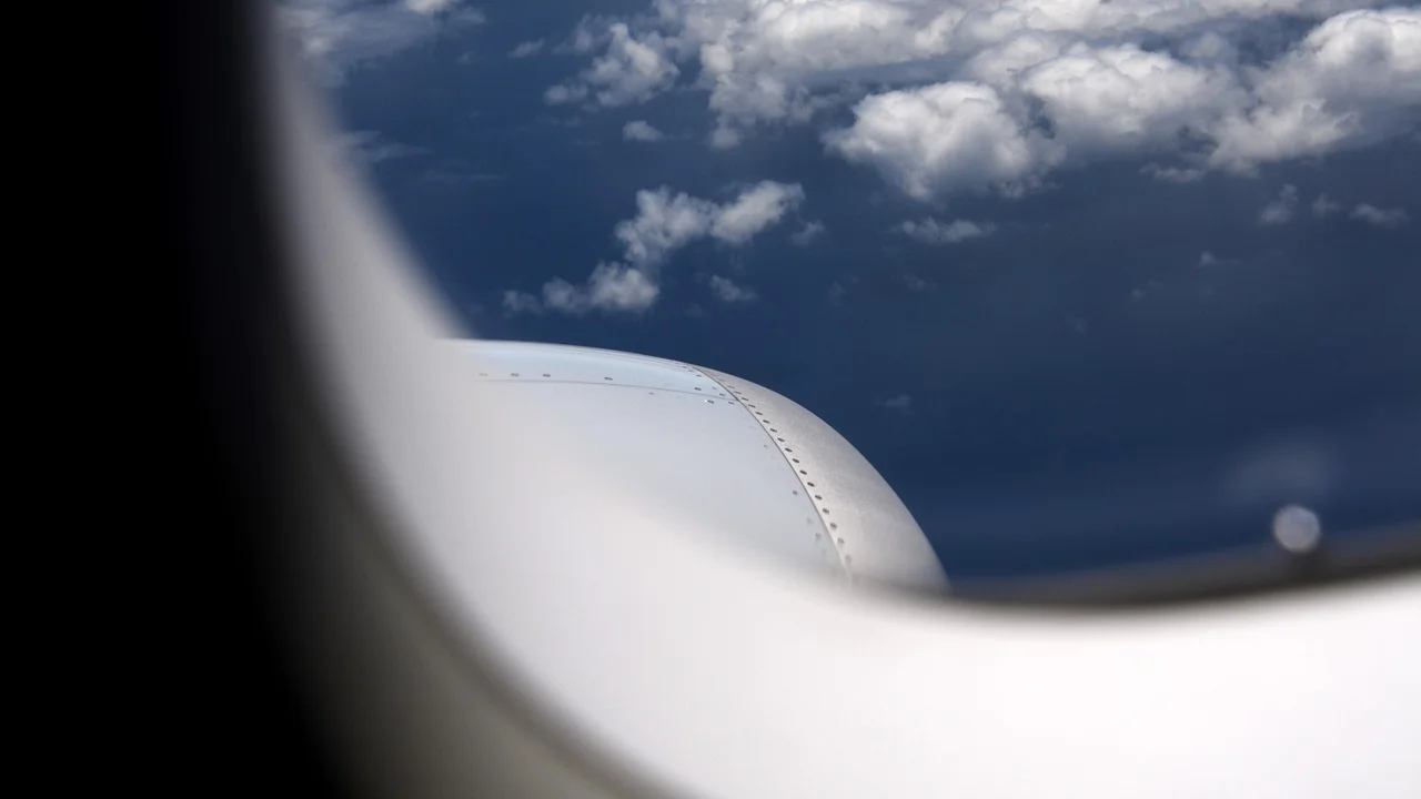 Avião visto pela janela durante um voo diurno