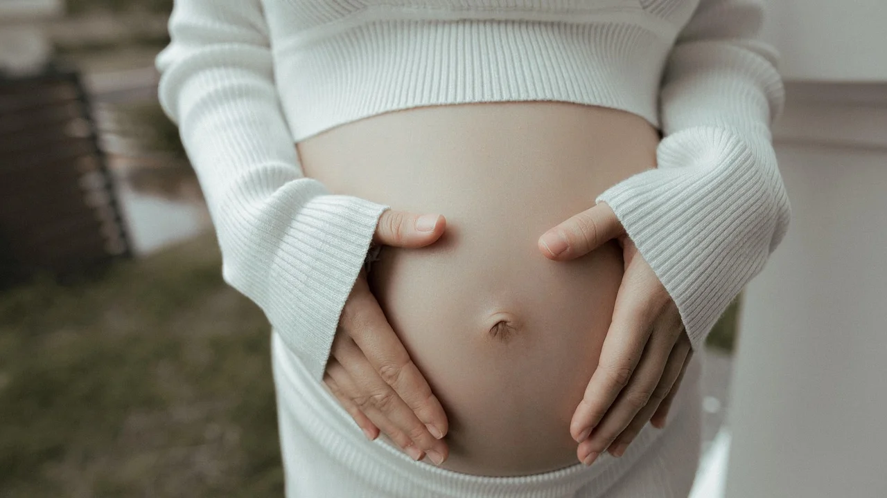 Mãos apoiadas sobre a barriga em imagem simbólica de gravidez.